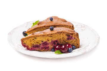 Homemade cake with cherries and blueberries on a white backgroun