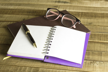 Fototapeta premium book with glasses and pen on the wooden background