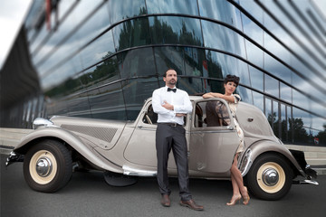 Model Paar mit Retro Auto Oldtimer vor Glasgebäude Porträt