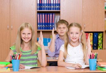 Children raising hands knowing the answer to the question