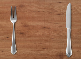 Table knife and fork on wood