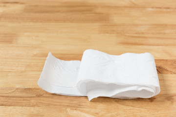 Toilet paper on wooden background.