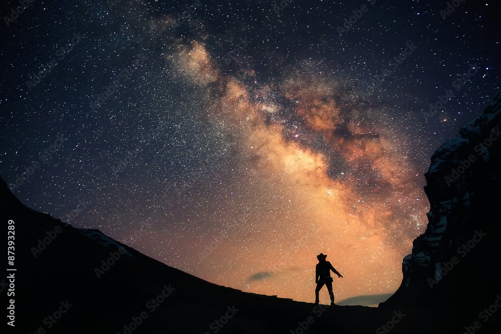 Wall mural guardian of the galaxy. a man is standing next to the milky way galaxy and the night sky full of sta