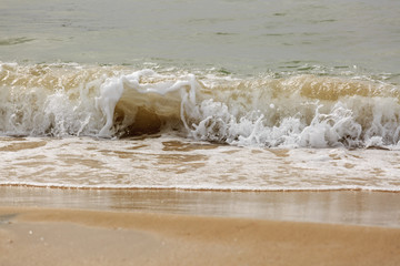 Splash of small wave with sand in Mediterranean Sea