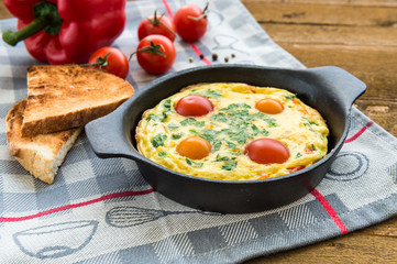 Frittata (italian omelet) with paprika and cherriy tomatoes. Direct view
