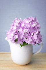 selective focus of sweet purple  hydrangea flowers in white vase