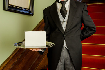 Butler mit Tablet und weißem Schild