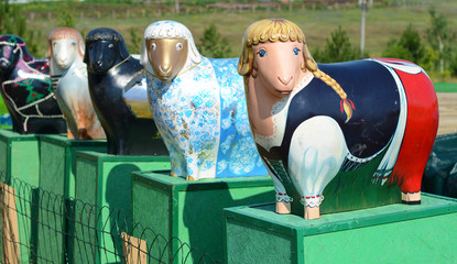 Several sculptures same cute sheep painted in different colors