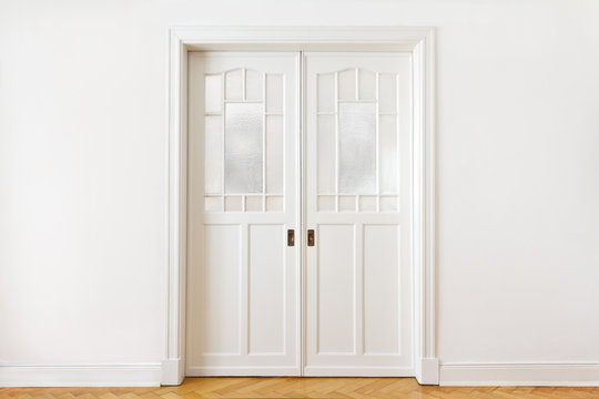 White wall with a double sliding door or pocket doors with textured glass, interior background, copy space.