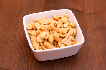 Salted nuts on bowl on wooden table