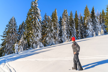 Young woman tourist standing on fresh snow in Gorce Mountains, Poland