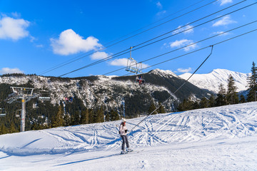 Fototapeta na wymiar Skier on lift in beautiful winter scenery of Tatra Mountains, Slovakia