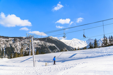 Unidentified skier on lift in beautiful winter scenery of Tatra Mountains, Slovakia