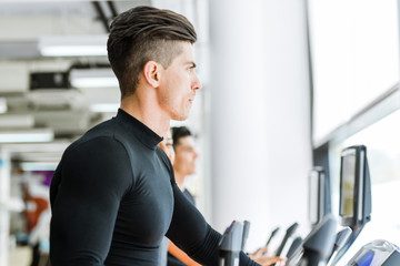 Young fit male jogging in a gym