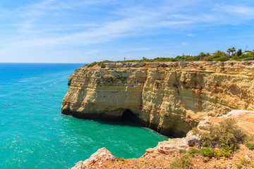 Turquoise sea and cliff rocks on coast of Portugal near Carvoeiro town, Algarve region