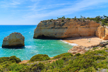 Cliff rocks and beautiful beach with turquoise sea water near Carvoeiro town on coast of Portugal