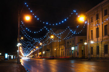 Cars move along Sovetskaya street under lights at night, Tver