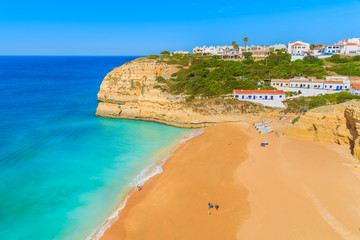 Obraz premium View of beautiful sandy Benagil beach and azure sea water in Algarve region, Portugal