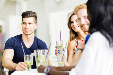 Young and happy friends sitting talking at a table
