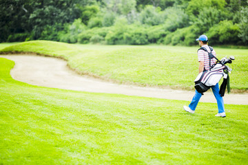 Golfer carrying his equipment