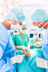 Krankenhaus - Ärzteteam im OP einer Klinik operiert einen Patienten