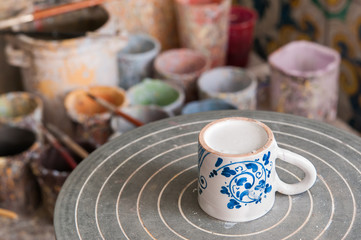 Ceramic coffee cup on the work table of a pottery decorator in Caltagirone