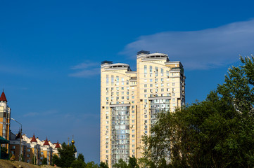 Group of modern multi-storey yellow and white big houses on background of blue sky