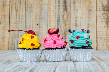 Colorful cupcakes on a wooden background