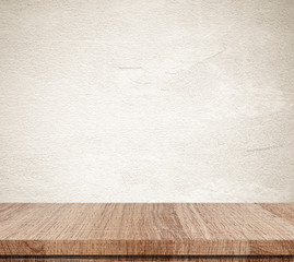 Empty wooden table over grunge cement wall background