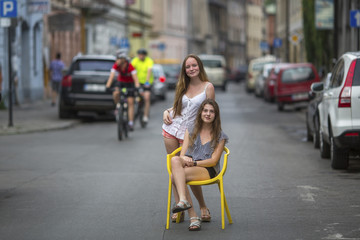 Two young best girlfriends in the old European town, conceptual photo about the vacation.