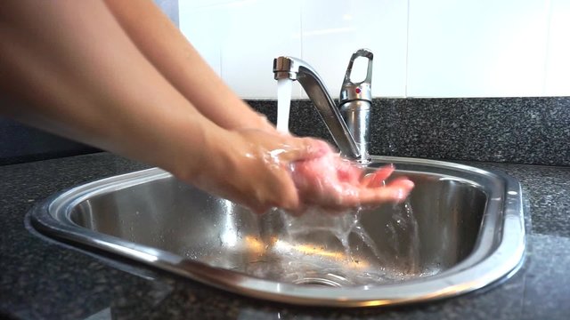 Washing hands with running water from tap