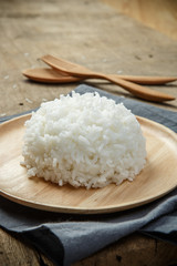 Organic White Rice in wooden dish on wooden table - soft focus