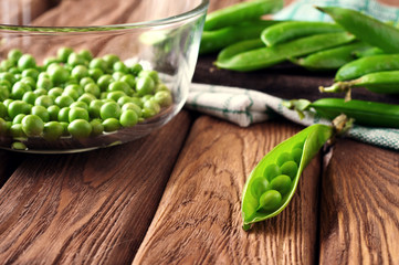 Open the pod green peas on wooden background