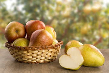 Some pears in a basket over a wooden surface seen from above