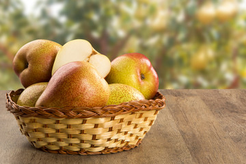 Some pears in a basket over a wooden surface seen from above