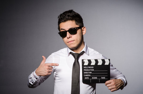 Young man in cool sunglasses holding chalkboard isolated on gray