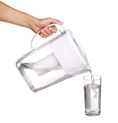 hand holding water filter jug and pouring water into a glass iso