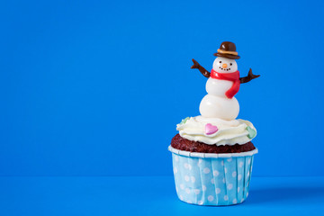 Snowman cupcakes on blue background