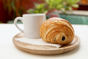 Chocolate pastry and coffee on wooden plate 