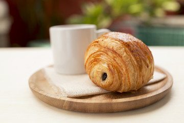 Chocolate pastry with coffee on wooden plate 