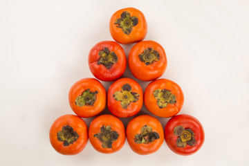 Some khaki fruits over a wooden surface