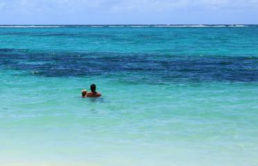 Fototapeta na wymiar plage et couple en lagon bleu de l'île Maurice