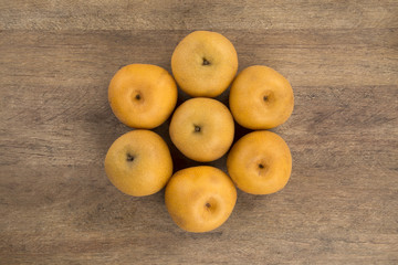 Some asian pears over a wooden surface