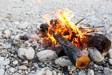 Self-made campfire on shore of mountain river