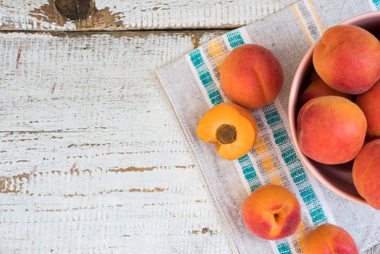 Fresh homegrown apricots on vintage white wooden table, view from above