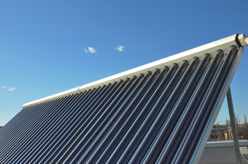 Fototapeta na wymiar Energy efficiency concept. Closeup of vacuum solar water heating system on the house metal roof
