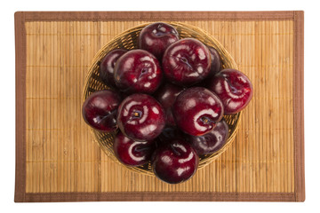 Fresh bright plums in the bowl on board
