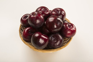 Fresh bright plums in the bowl on board