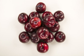 Fresh bright plums in the bowl on board