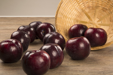 Fresh bright plums in the bowl on board